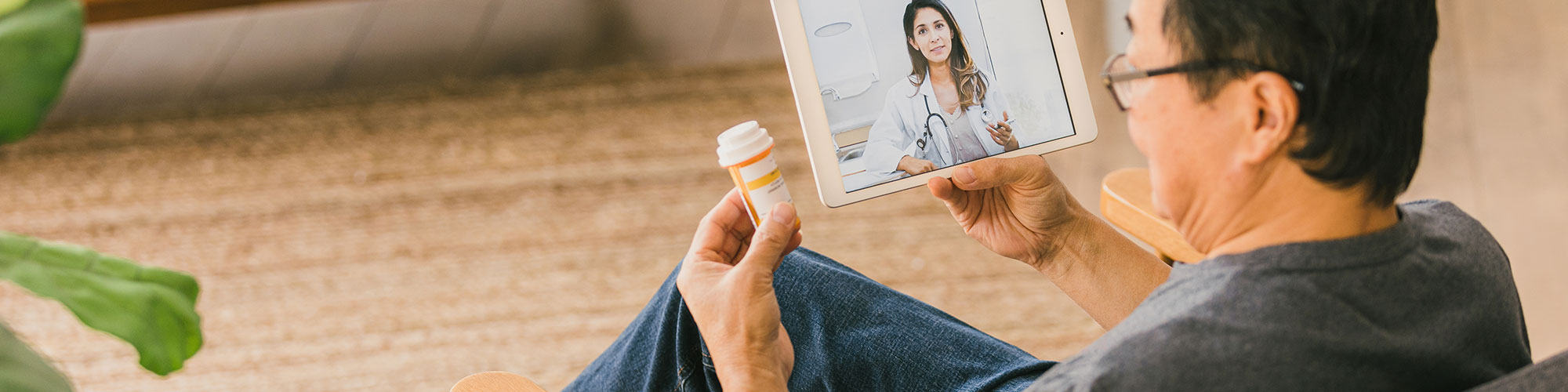 Patient holding bottle of prescribed medication on a telehealth call with provider